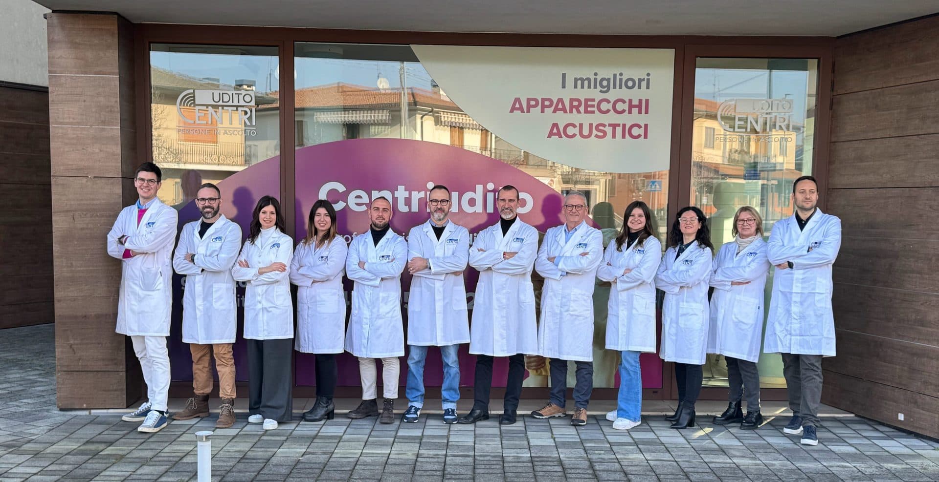 Il team Centriudito al completo, in camice davanti alla vetrina di un centro